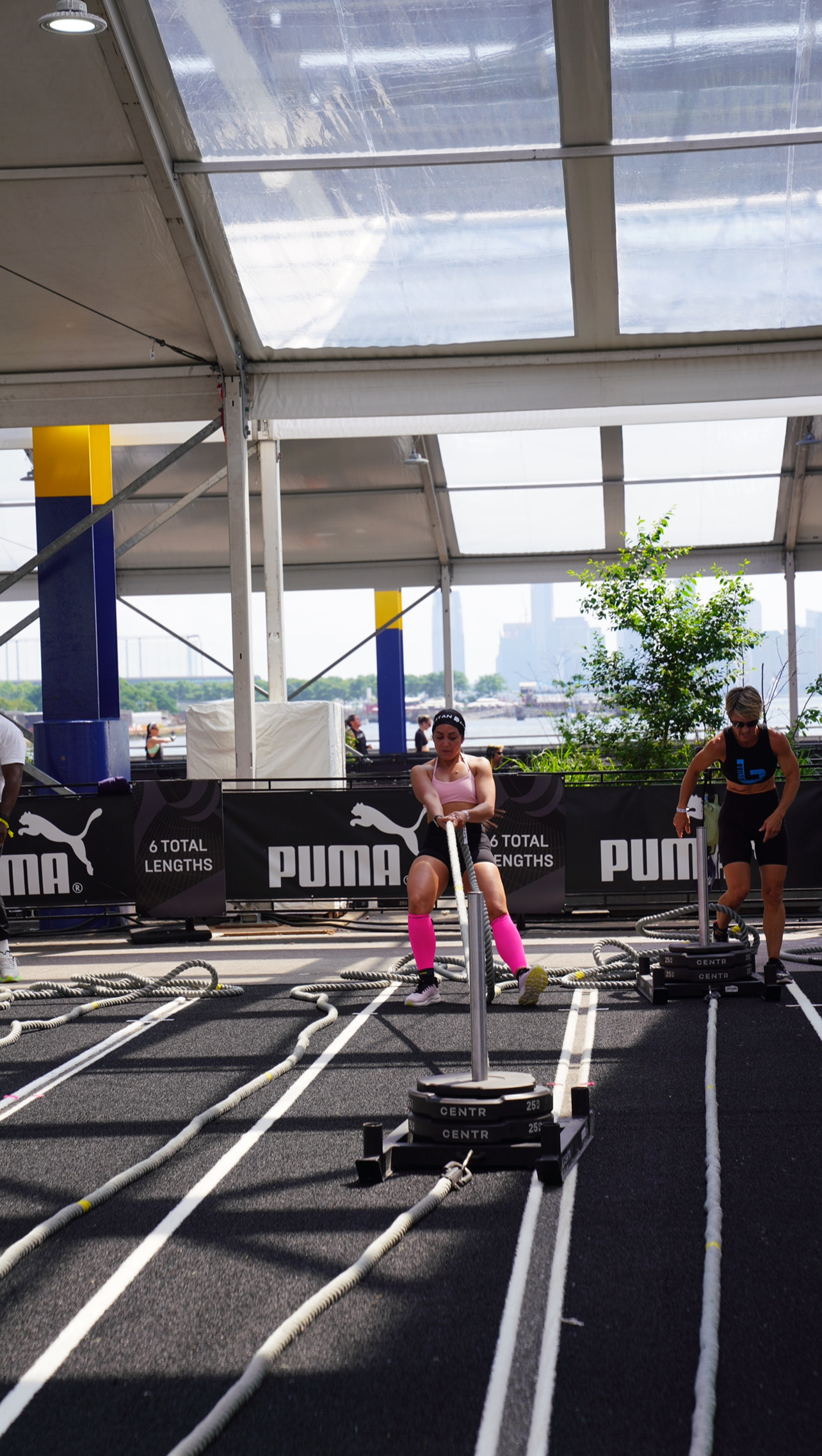 Community member performing sled push at outdoor HYROX event