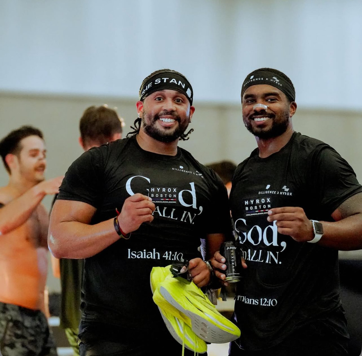 Teammates celebrating together with HYROX race bibs