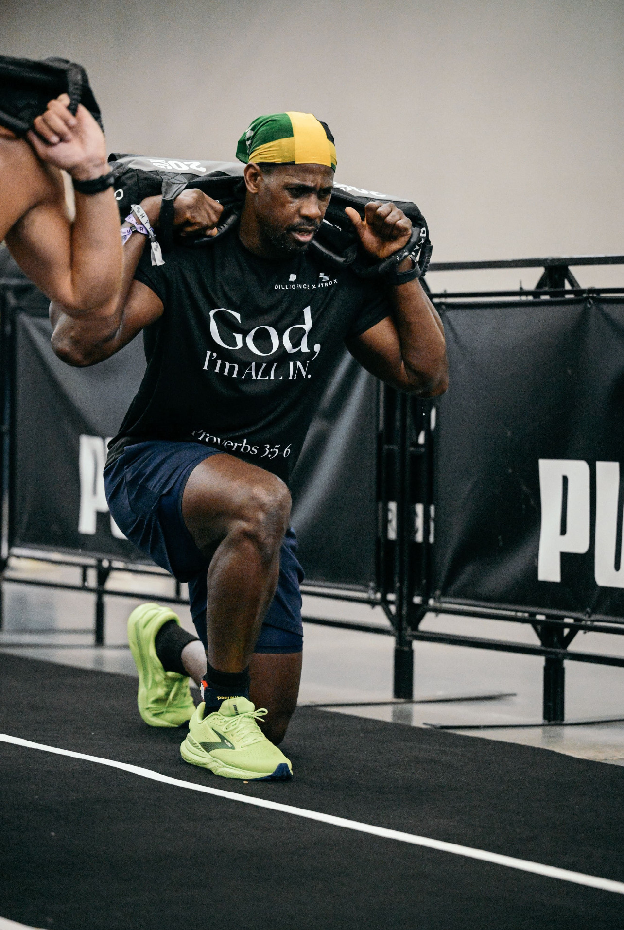 HYROX athlete performing lunges with weighted sandbag